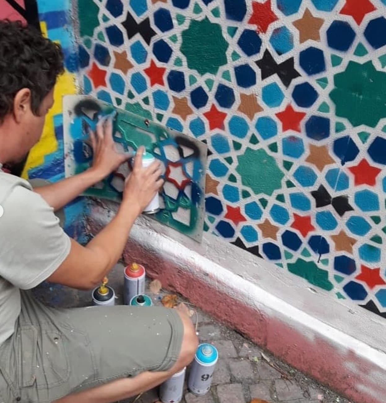Guilherme Lemmi pinta um padrão geométrico em um muro
